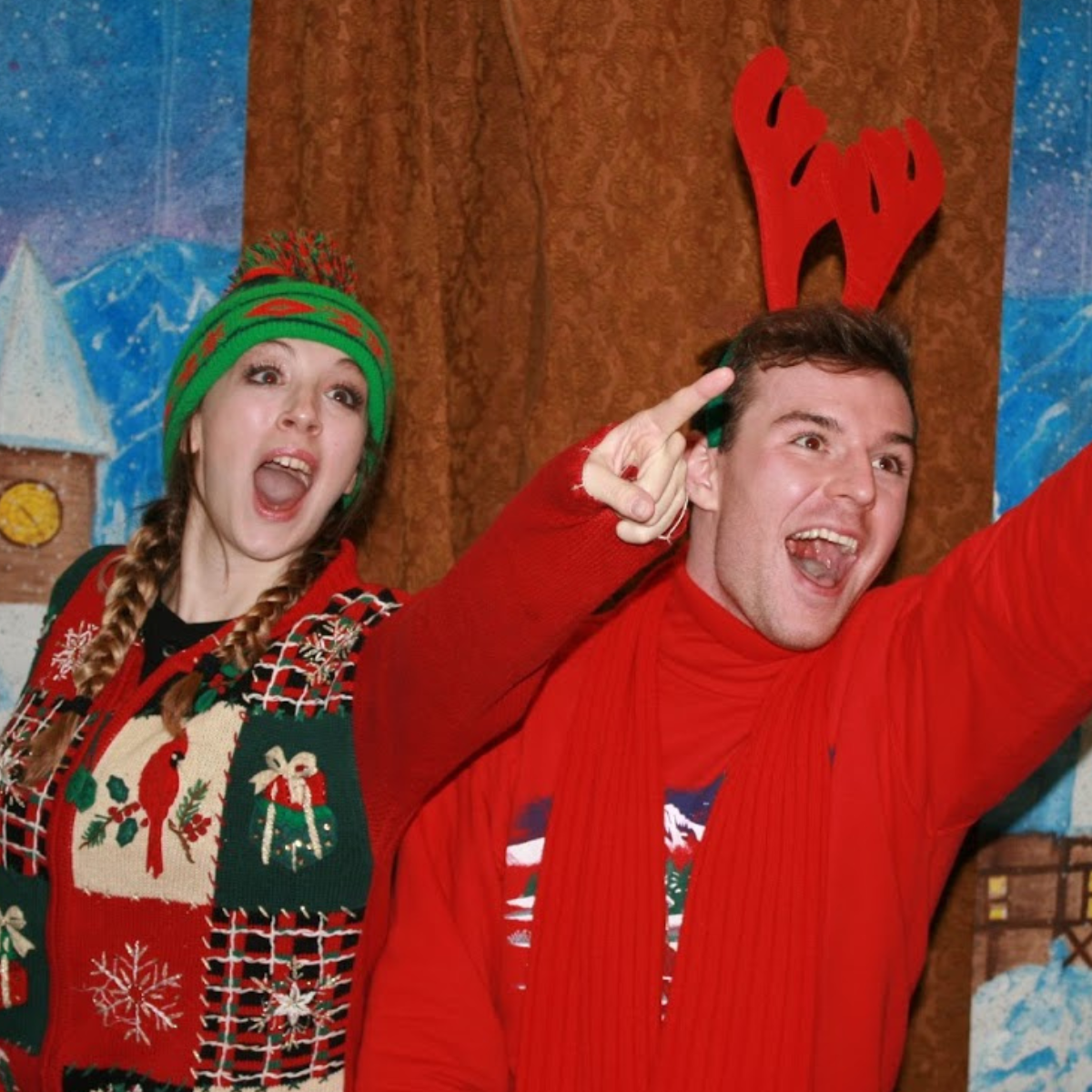 woman and man wearing holiday sweaters and pointing to the side