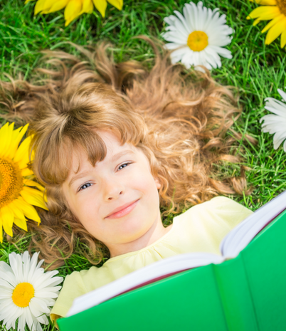 girl holding green book with grass and flowers