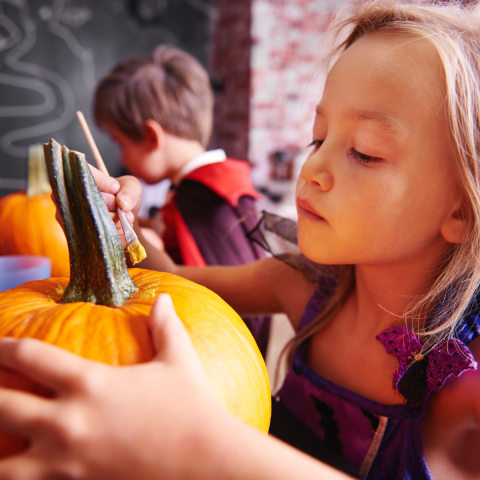 girl painting a pumpkin