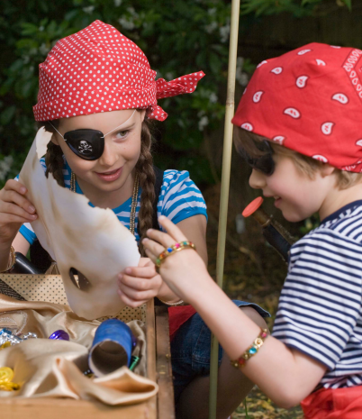 children in pirate costumes looking at a map