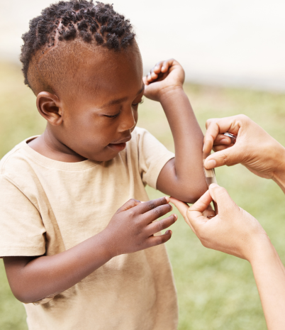 boy receiving first aid bandage on his arm