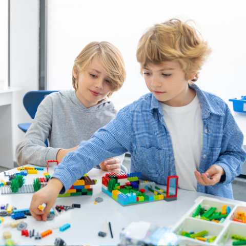 children building with multicolored LEGO blocks