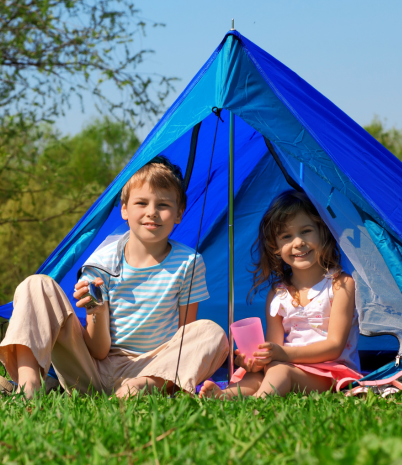 2 children sitting inside a blue tent