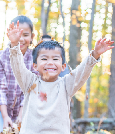 child playing in leaves